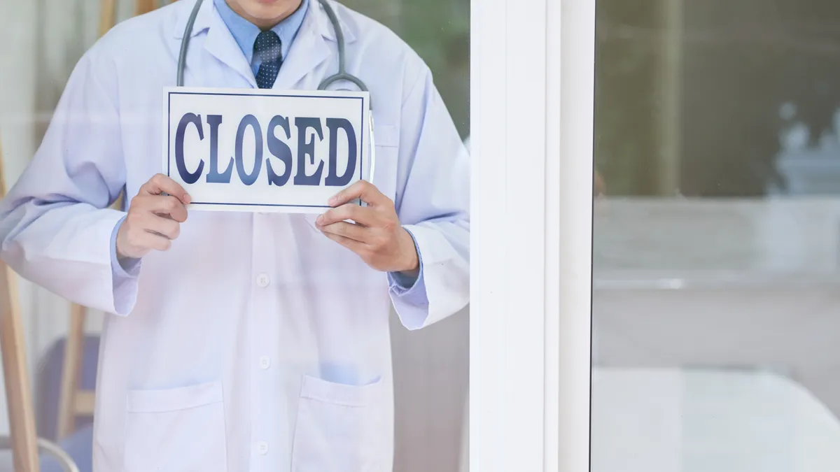 Doctor puts closed sign up in hospital