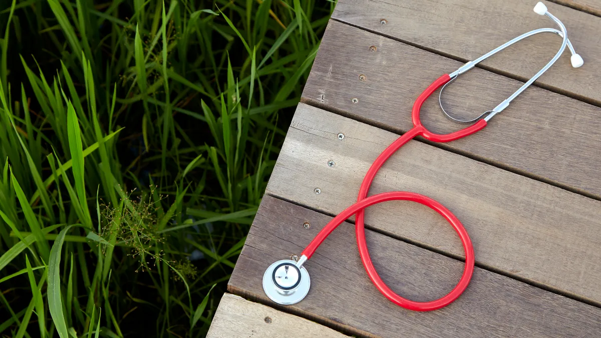 A red stethoscope sitting on a picnic table.