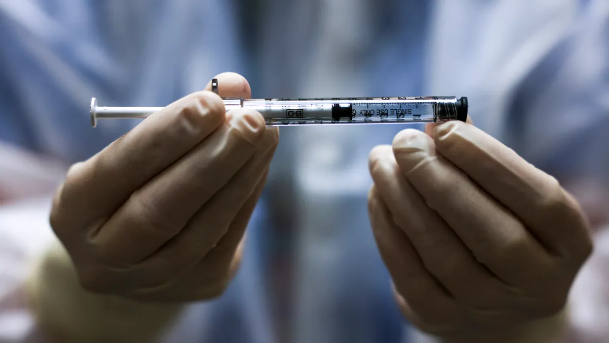 Hands holding a COVID-19 vaccine