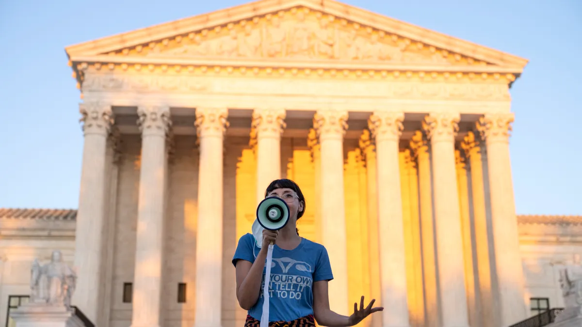 women standing in front of court-house with a megaphone