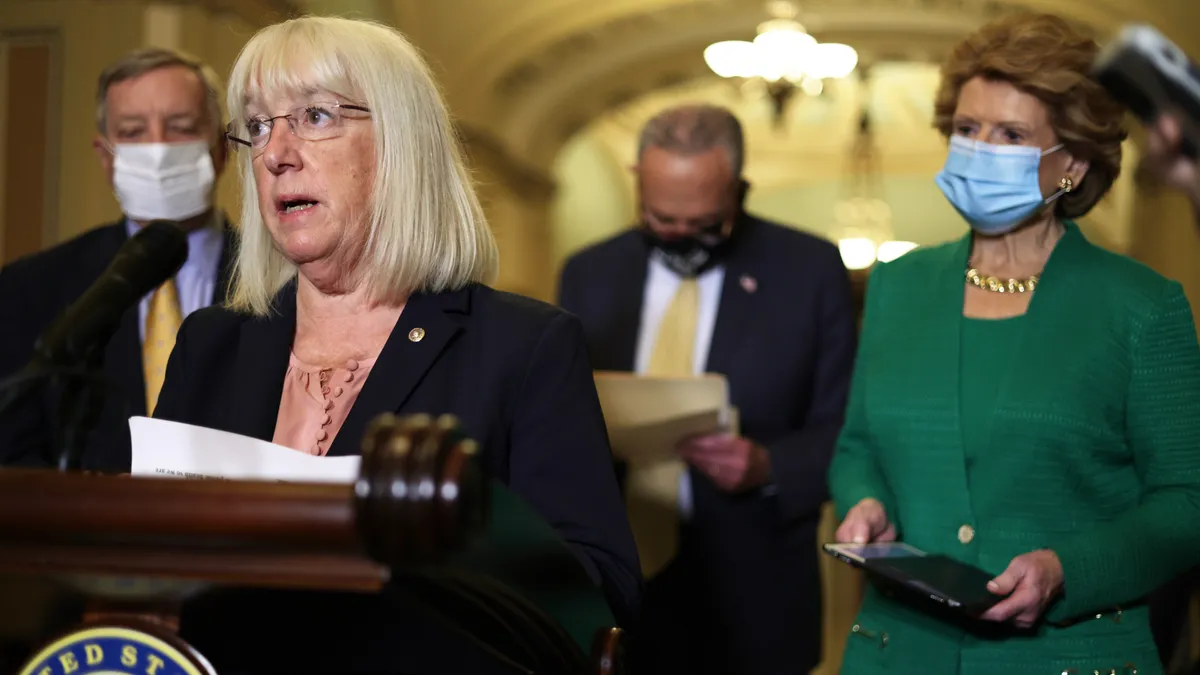 Sen. Patty Murray speaks at a podium flanked by Sen. Debbie Stabenow.