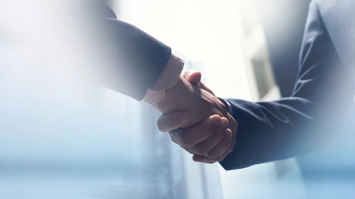 Two people shake hands in a stock photo.