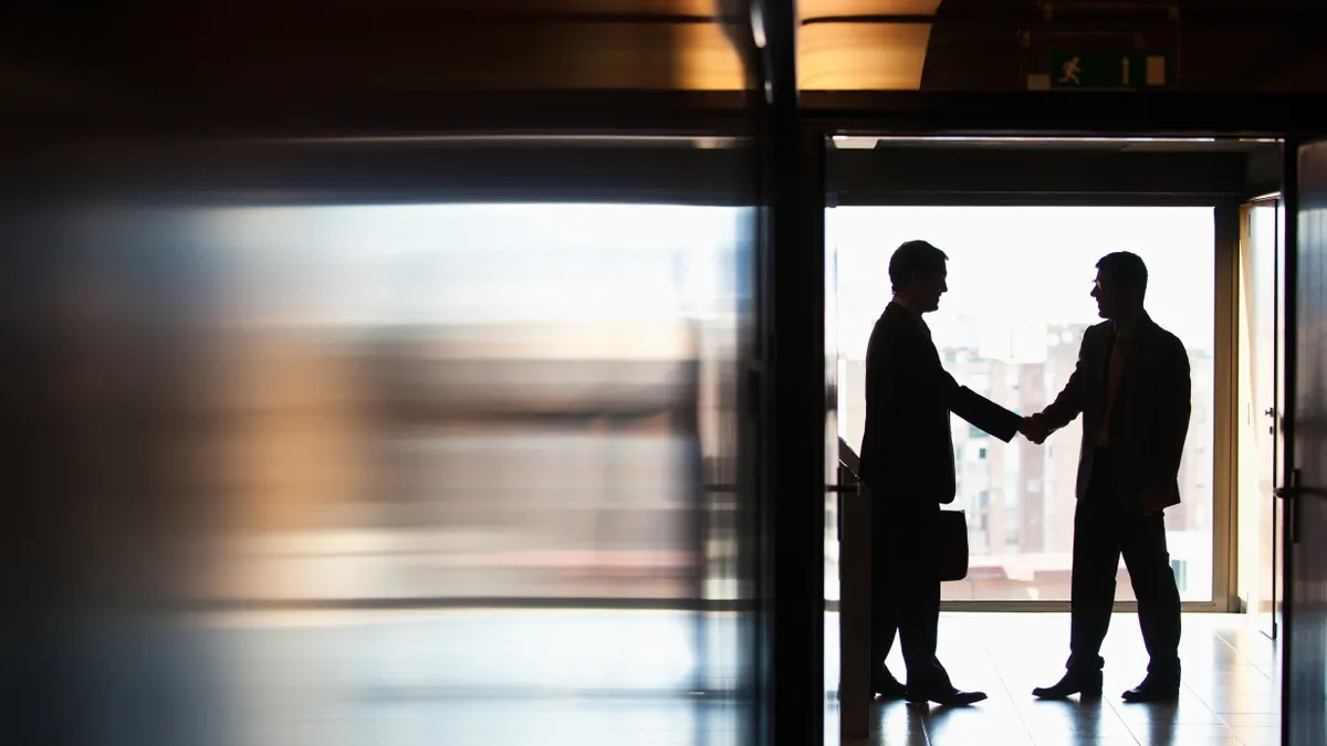 Two executives shaking hands.