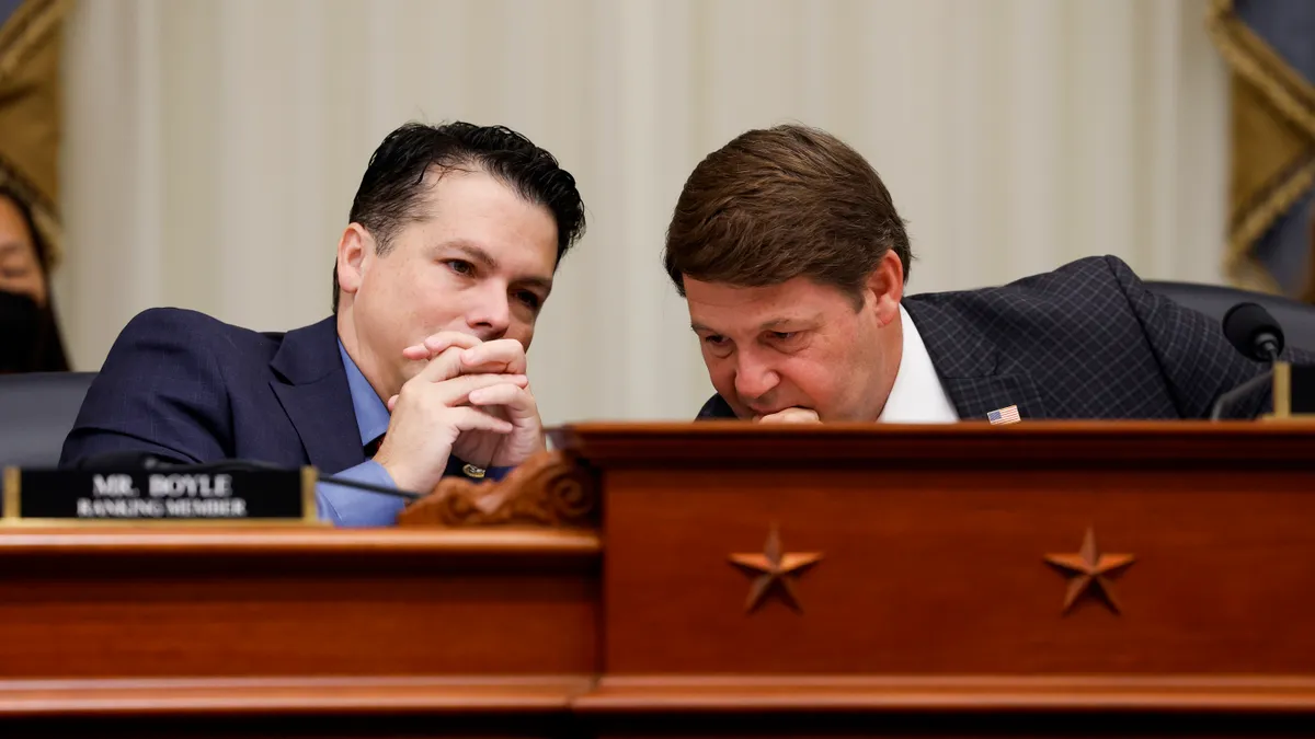 Congressmen Brendan Boyle and Jodey Arrington lean toward one another while having a seated discussion.