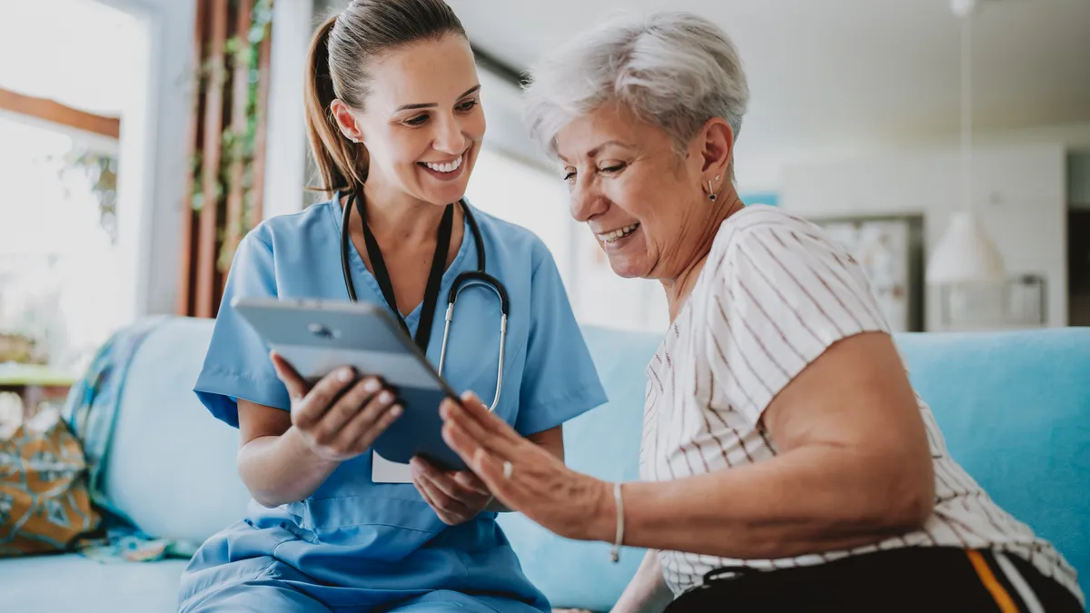 Nurse talking to a senior woman using a tablet