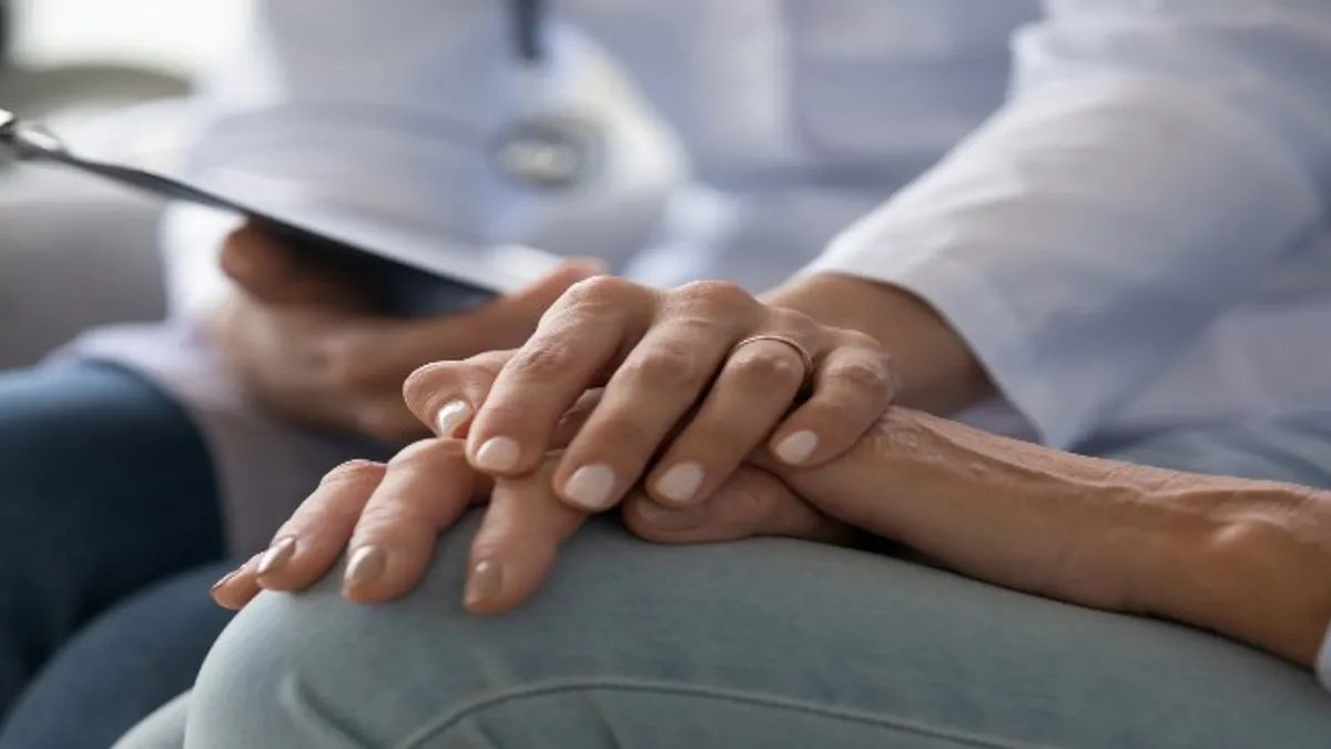 Young female doctor holding patient  hand.