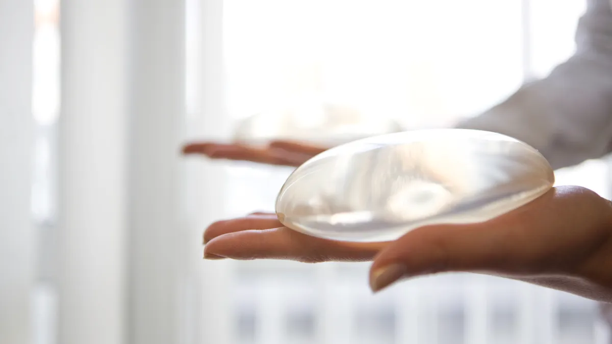 A person holds a transparent, oval shaped device