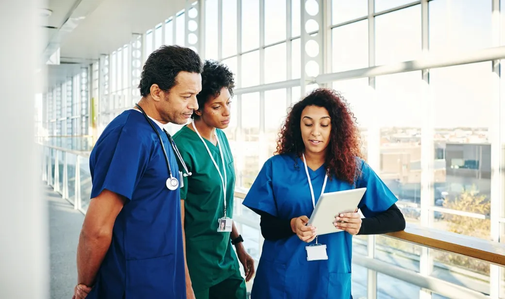 Nurses collaborating in hospital hallway