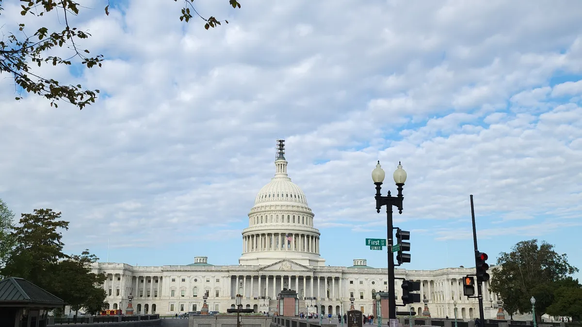 The front of the U.S. Capital with white clouds and blue sky.