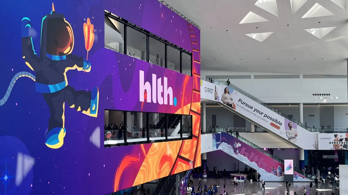 The HLTH logo on a massive screen at the entrance hall to the convention.