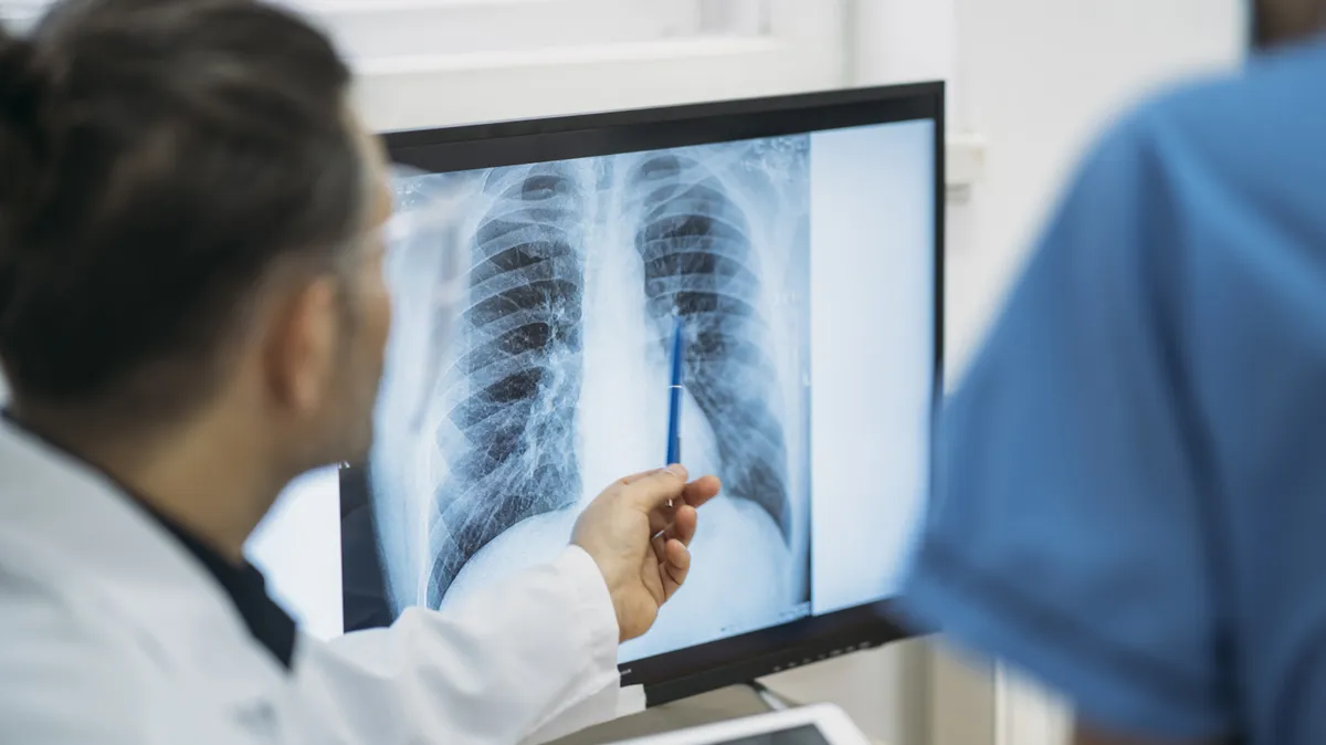 physicians exmaine an xray on a monitor